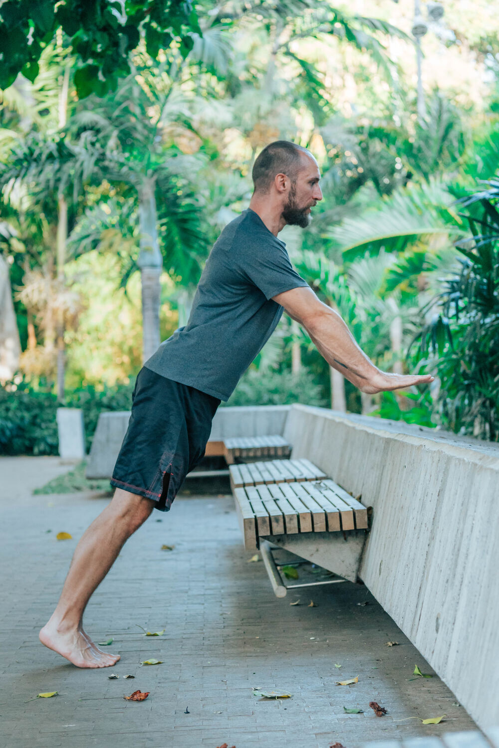Joe doing an incline push-up against a concrete bench in a park
